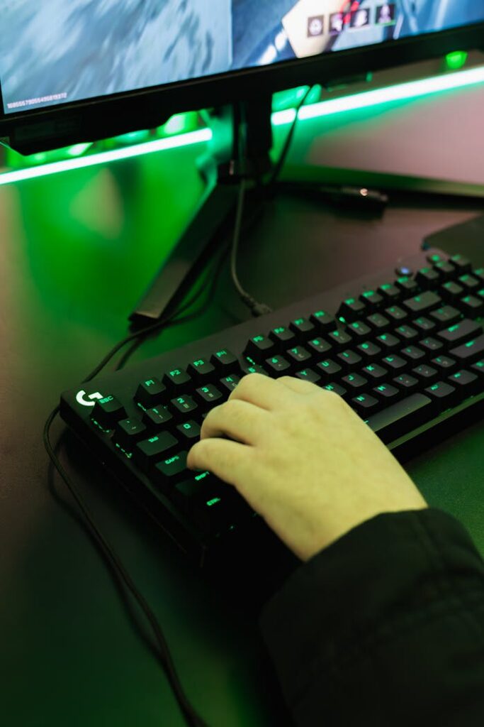 Close-up of hand gaming on a black mechanical keyboard with green lighting.